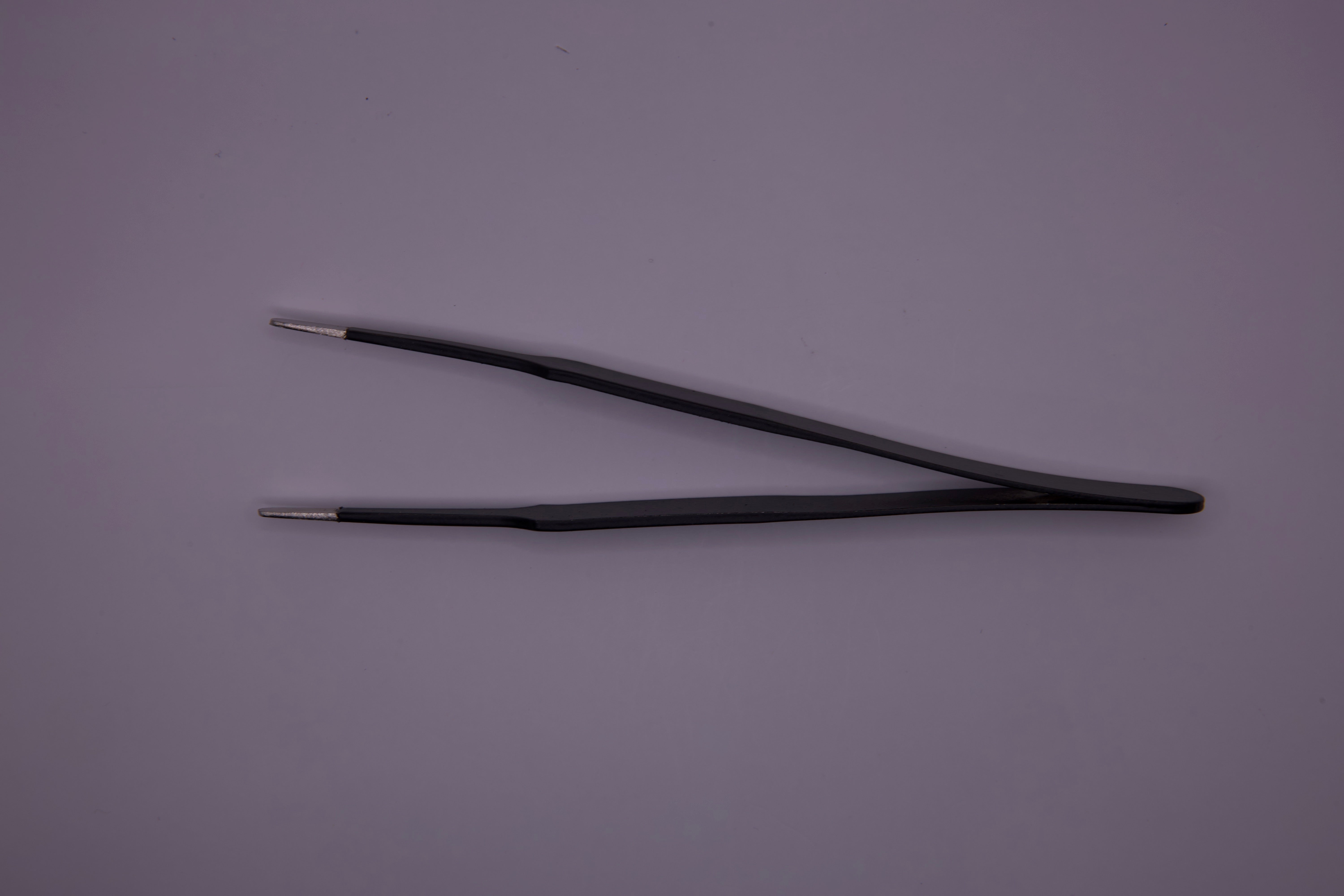 Zoomed-in detail of Precision Tweezers' fine tips against a graphics background.